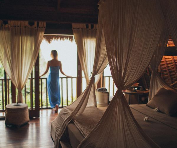 Person meditating peacefully in a room with soft, natural light.